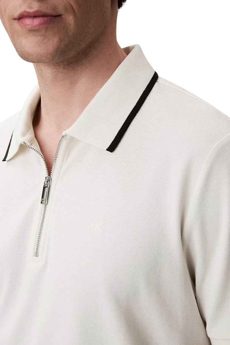 Sporline Calvin Klein beyaz fermuarlı polo yaka erkek tişört, %100 pamuklu kumaş ve siyah detaylı yaka tasarımı.
