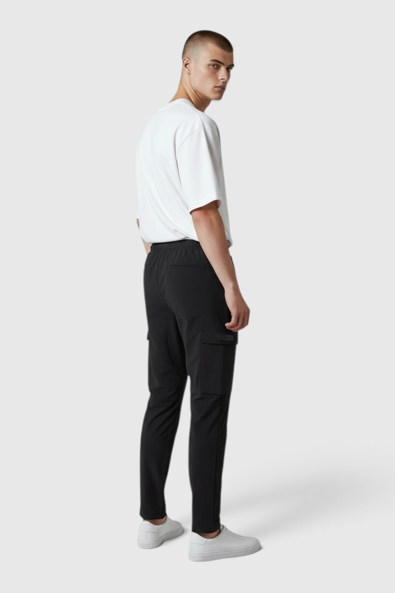 Sporline New Balance siyah erkek eşofman altı, polyester ve elastan karışımlı, kargo cepli, arkadan görünüm