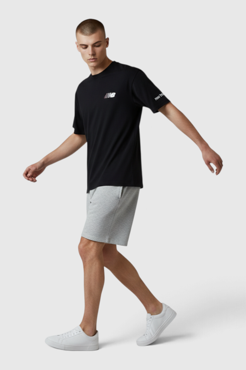 Sporline New Balance siyah regular kesim erkek tişört giyen model, gri şort ve beyaz spor ayakkabı ile kombinlenmiş