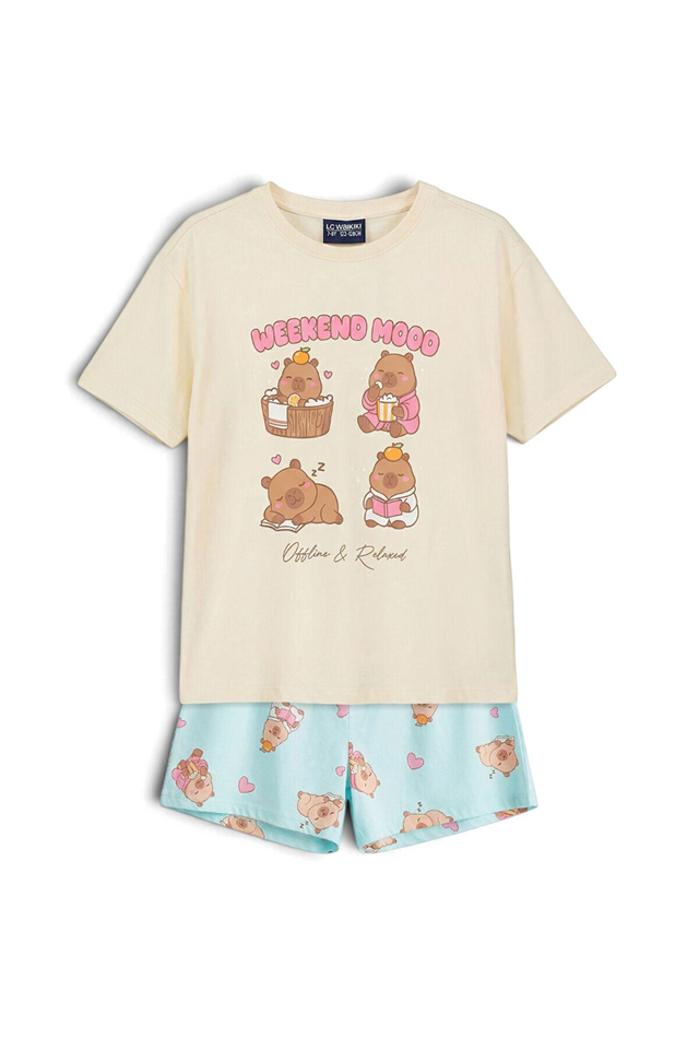 Sporline LC Waikiki kırık beyaz renkli, baskılı tişört ve desenli şorttan oluşan %100 pamuklu kız çocuk pijama takımı