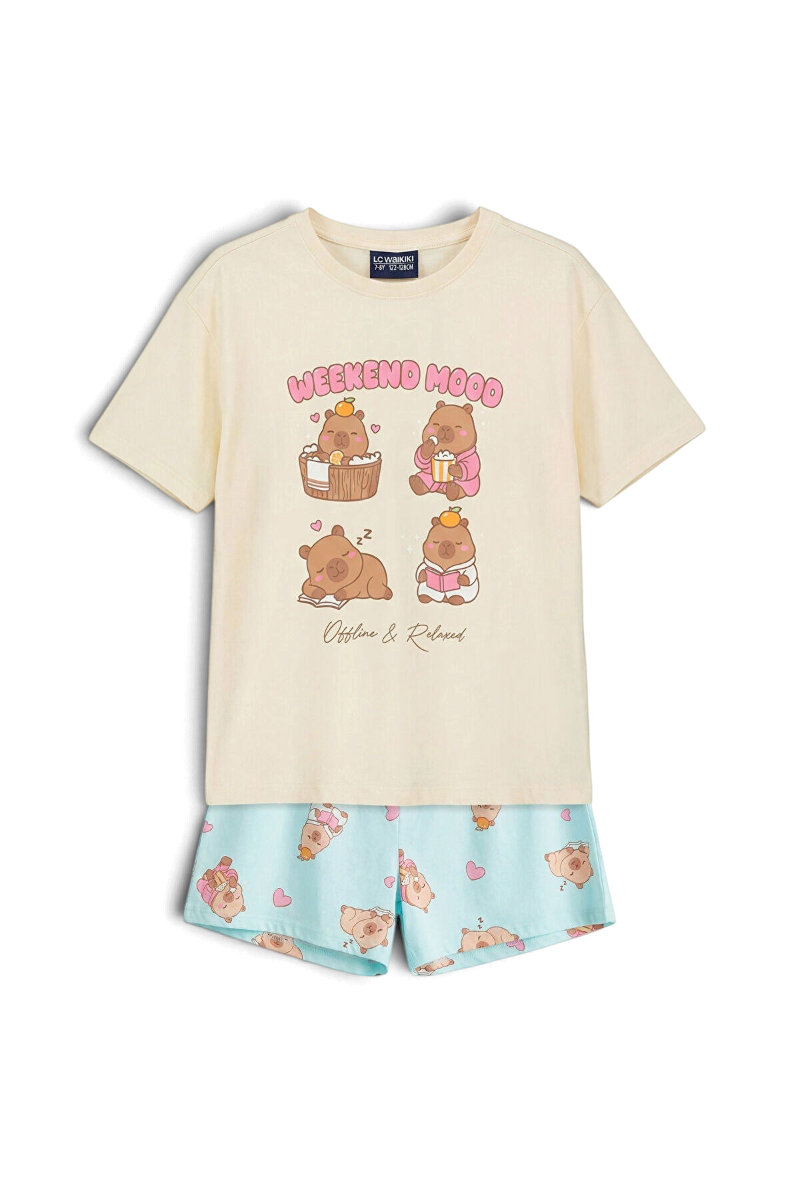 Sporline LC Waikiki kırık beyaz renkli, baskılı tişört ve desenli şorttan oluşan %100 pamuklu kız çocuk pijama takımı