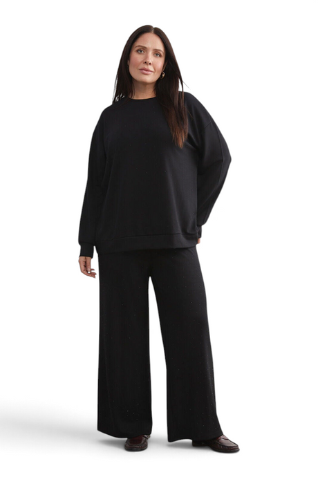 Sporline LC Waikiki siyah pamuklu kadın eşofman altı ve uyumlu sweatshirt takımı giyen model