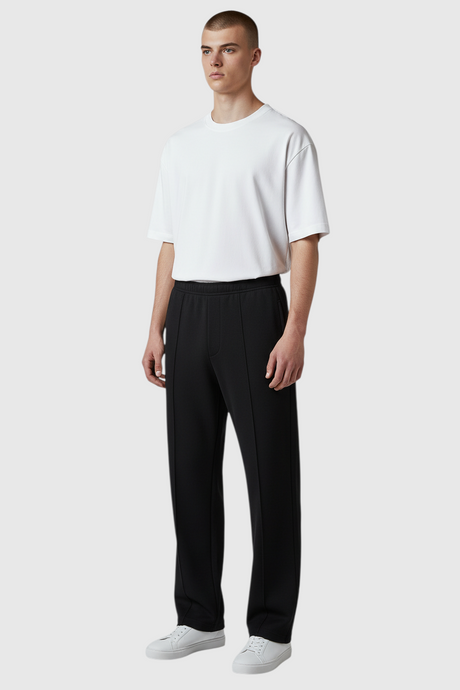 Sporline New Balance antrasit renkli, jogger kesim, tekstil unisex eşofman altı giyen erkek model.