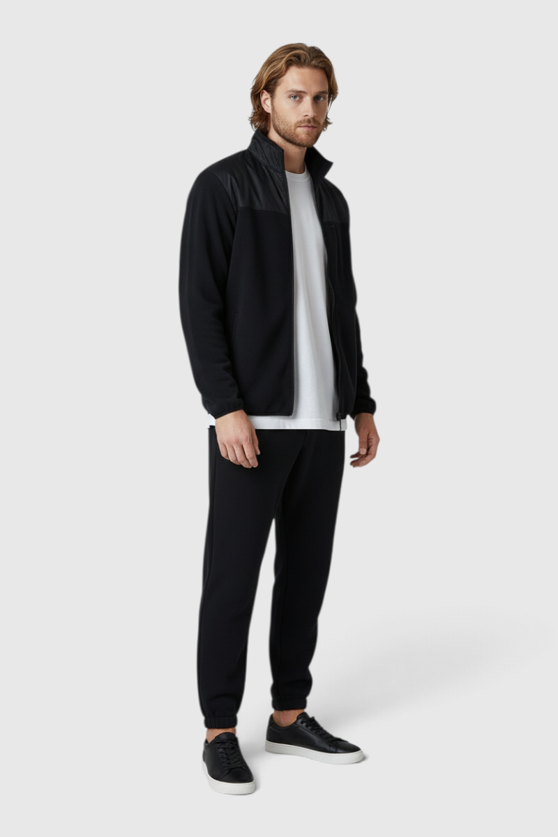 Sporline New Balance siyah polyester erkek mont, regular kesim, fermuarlı tasarım, beyaz tişört ile kombinlenmiş.