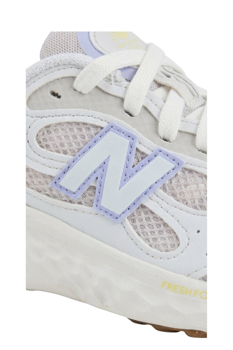 Sporline New Balance beyaz fileli kadın spor ayakkabı, yan kısımdaki lila detaylı N logosu ve yumuşak taban yapısı.
