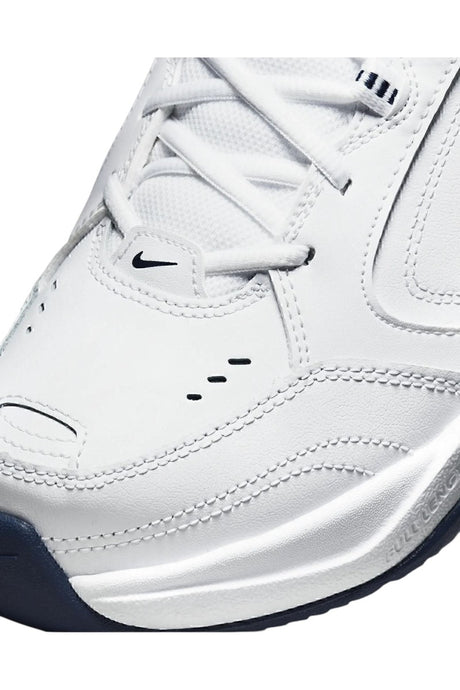 Sporline Nike Air Monarch IV erkek spor ayakkabı, beyaz deri yüzeyli ve siyah Nike logolu detaylı yakın çekim.
